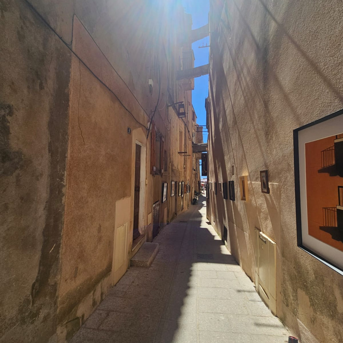Ruelle étroite pavée bordée de hautes maisons en pierre dans la vieille ville de la citadelle de Bonifacio, en Corse.