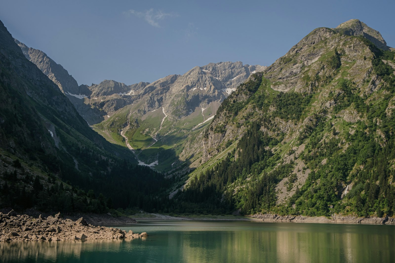Lac alpin reflétant les sommets enneigés au lever du jour