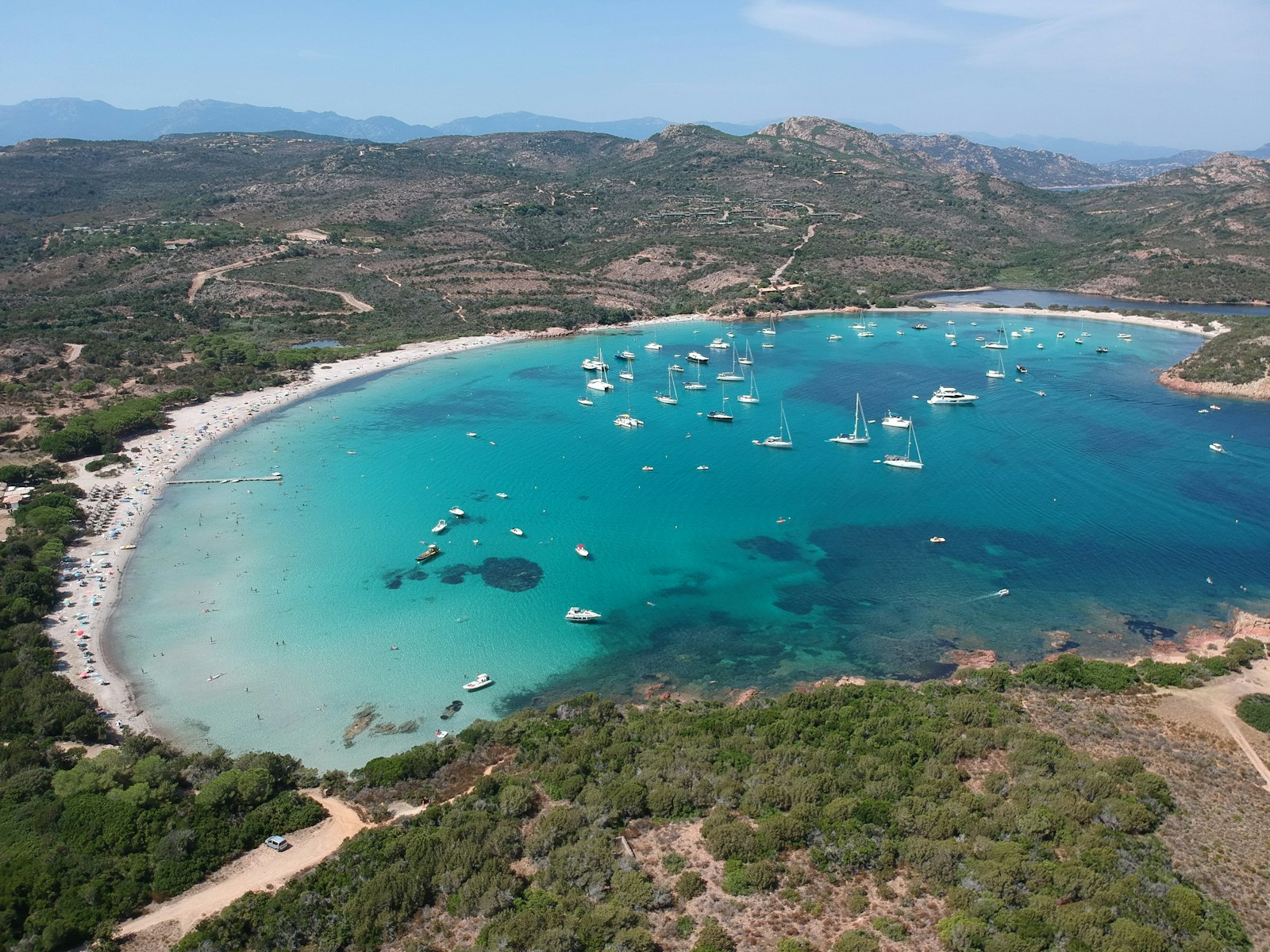 Crique aux roches rouges et eau turquoise sur la côte corse