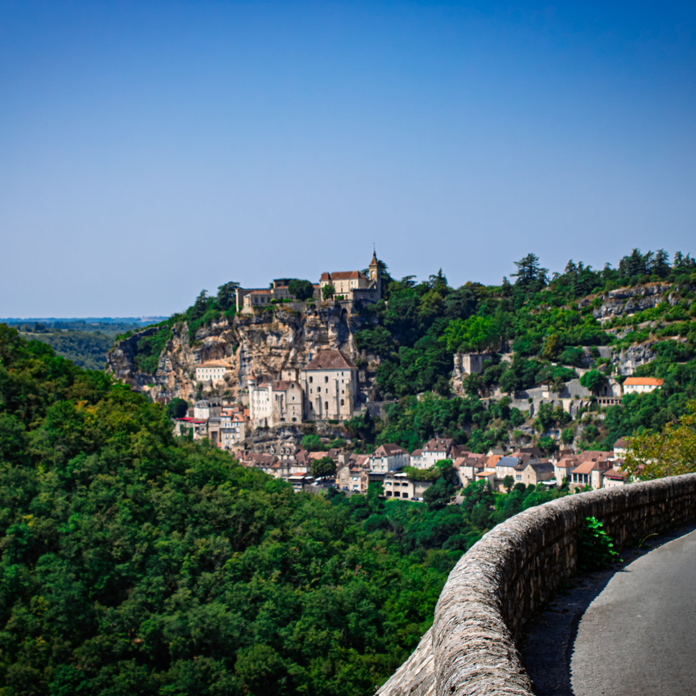 Cité médiévale de Rocamadour accrochée à la falaise calcaire, avec ses sanctuaires, ses toits en lauze et son château dominant la vallée de l'Alzou.